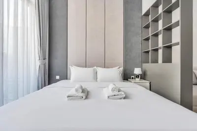 a bedroom with a white bed with towels on it at DAYF-SER03 Brand New Studio with Balcony in JVC in Dubai