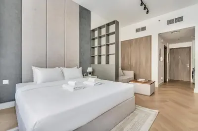 a bedroom with a large white bed in a room at DAYF-SER03 Brand New Studio with Balcony in JVC in Dubai