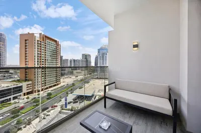 a living room with a couch and a view of a city at Luxury Escapes Modern Studio MAG 318 in Dubai