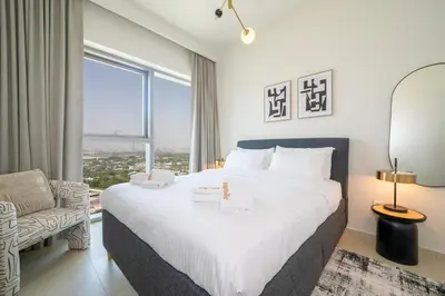 a bedroom with a large bed and a window at Zapbed House -Stylish 1 BR Apartment Downtown Views II Tower 2 in Dubai