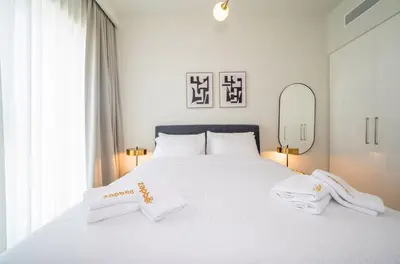 a white bed with two white pillows and a mirror at Zapbed House -Stylish 1 BR Apartment Downtown Views II Tower 2 in Dubai