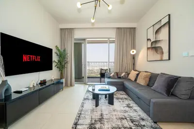 a living room with a couch and a tv at Zapbed House -Stylish 1 BR Apartment Downtown Views II Tower 2 in Dubai