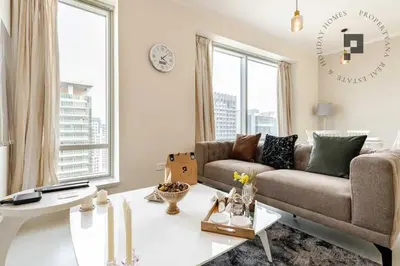 a living room with a couch and a table at Cozy 1BR in Burj Views I Top Location Walk to Dubai Mall & Burj Khalifa I Wi-Fi in Dubai