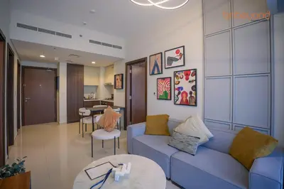 a living room with a blue couch and a table at Bnbeyond's Canal Dreams and Luxe 2BR in Dubai