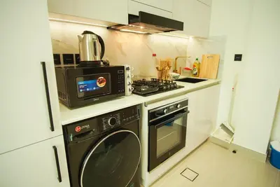 a kitchen with a stove and a microwave at Brand New Studio In Tulip JVC in Dubai