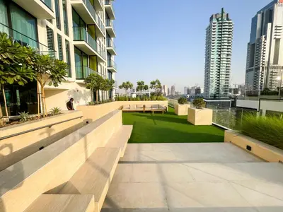 a balcony of a building with benches and grass at Brand New Studio In Tulip JVC in Dubai