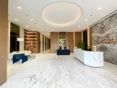 a lobby of a hotel with a man sitting at a counter at Brand New Studio In Tulip JVC in Dubai