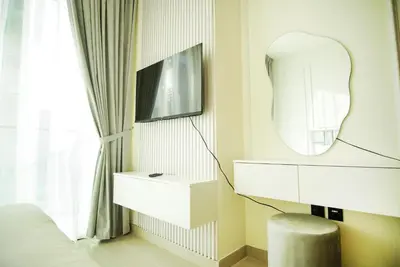 a bedroom with a mirror and a white dresser at Brand New Studio In Tulip JVC in Dubai