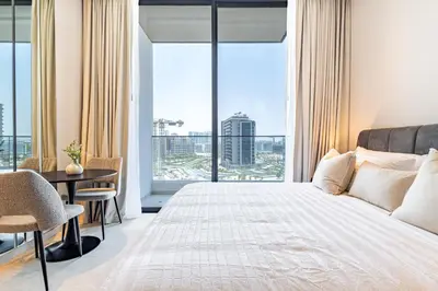 a bedroom with a bed and a large window at SuperHost- Modern Studio in Arjan with pool & Gym in Dubai