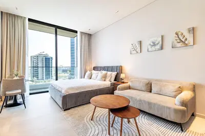 a living room with a couch and a bed at SuperHost- Modern Studio in Arjan with pool & Gym in Dubai