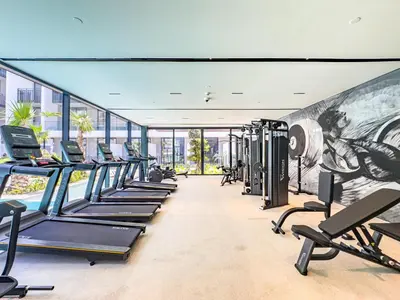 a gym with a row of treadmills and machines at SuperHost- Modern Studio in Arjan with pool & Gym in Dubai