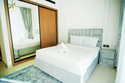 a bedroom with a large white bed and a mirror at 1bhk brand new in JVC Binghatti Lavender in Dubai