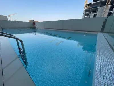 a large blue swimming pool on top of a building at 1bhk brand new in JVC Binghatti Lavender in Dubai