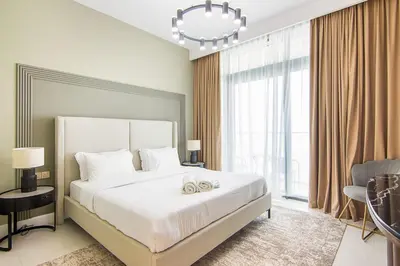 a bedroom with a large bed and a chandelier at Sea View 2BR Apartment in Beach Vista 2 in Dubai