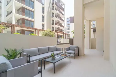 a patio with a couch and tables in a building at Frank Porter - Groove at Creek Beach in Dubai