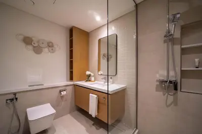 a bathroom with a shower and a toilet and a sink at Frank Porter - Creek Crescent Tower 1 in Dubai