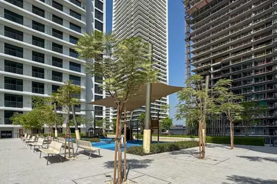 a courtyard with chairs and trees and buildings at Brand New Stylish 1-Bed Getaway with Private Beach and Palm Views in Dubai