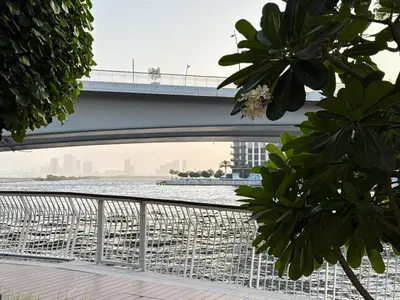 a bridge over a river with a bridge in the background at Creek New Luxury Stay Beach and Lagoona Access in Dubai
