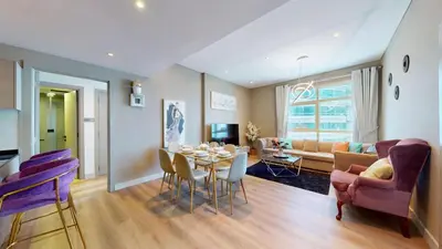 a dining room and living room with a table and chairs at Vacationer I Steps to Metro I Premium 2 Bedroom Apartment I Yacht Bay Marina in Dubai