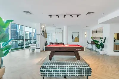 a living room with a pool table in it at Vibrant Waterfront Duplex in Dubai Marina in Dubai