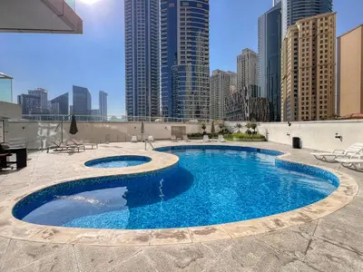a swimming pool on top of a building with tall buildings at Vibrant Waterfront Duplex in Dubai Marina in Dubai