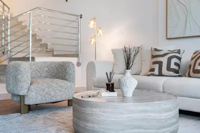 a living room with a couch and a chair and a coffee table at Vibrant Waterfront Duplex in Dubai Marina in Dubai