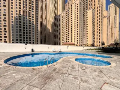 a pool in the middle of a city with tall buildings at Vibrant Waterfront Duplex in Dubai Marina in Dubai