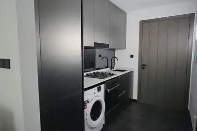 a kitchen with a stove and a washing machine at Brand New , Skyline View in Dubai
