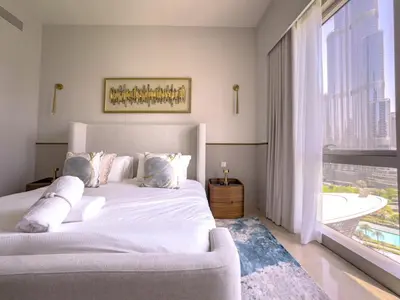 a bedroom with a white bed and a large window at GRANDE SIGNATURE with a direct Burj Khalifa view and Private Fountain Show at high floor with DXB AIRPORT VIP Shuttle option for 8 guests in Dubai
