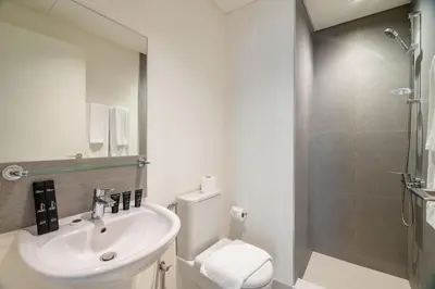 a bathroom with a sink and a toilet and a shower at Luxurious 4BR with Boulevard View - 10 min to Burj & Mall in Dubai
