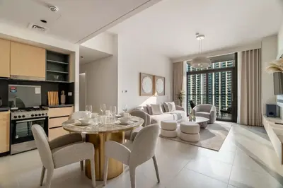 a kitchen and living room with a table and chairs at Luxurious 4BR with Boulevard View - 10 min to Burj & Mall in Dubai