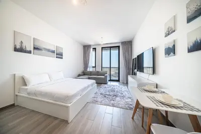 a bedroom with a bed and a living room at Studio in Dubai Production City in Dubai