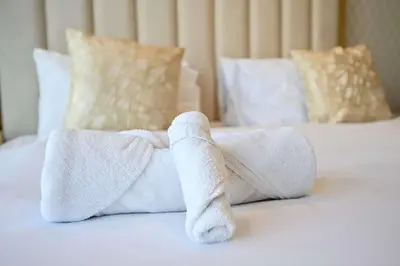 a pair of white towels on a bed at Amazing 2 Bed Burj views in Dubai