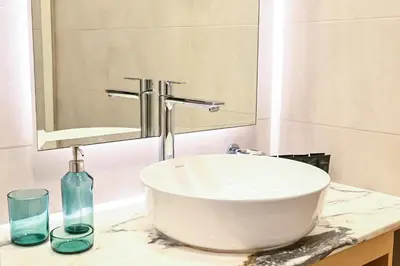a bathroom with a white sink and a mirror at Amazing 2 Bed Burj views in Dubai