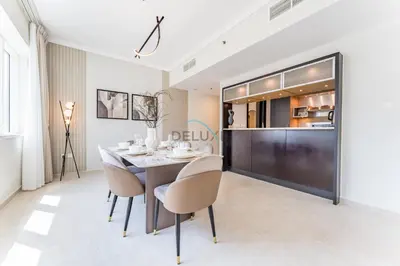 a dining room with a table and chairs and a kitchen at 2BR with Marina View, Walking Distance to Marina Mall, Metro Station & JBR Beach, Al Majara 1, Dubai Marina by Deluxe Holiday Homes in Dubai