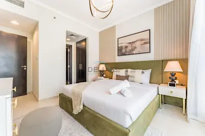 a bedroom with a large white bed and a table at 2BR with Marina View, Walking Distance to Marina Mall, Metro Station & JBR Beach, Al Majara 1, Dubai Marina by Deluxe Holiday Homes in Dubai