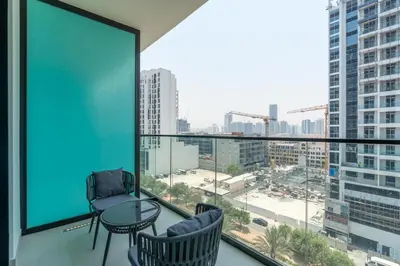 a balcony with a table and chairs and a large window at Ahlan HH - Brand New Summer Suite, Near Circle Mall in Dubai