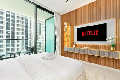 a bedroom with a bed and a tv on a wall at Ahlan HH - Brand New Summer Suite, Near Circle Mall in Dubai
