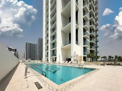 a swimming pool in front of a building at Feel at Home Stylish 1BR in Binghatti Tulip Dubai in Dubai