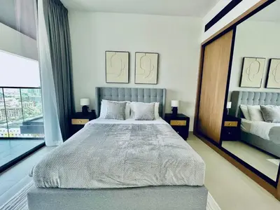 a bedroom with a large bed and a large window at Modern 1br In Jvc Balcony Pool Free Parking in Dubai