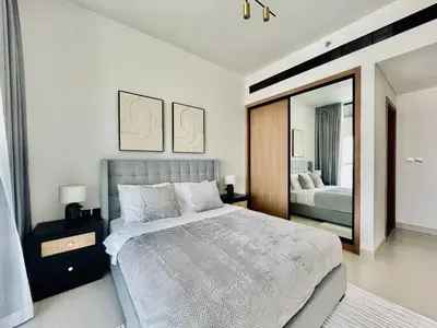 a bedroom with a large bed and a mirror at Modern 1br In Jvc Balcony Pool Free Parking in Dubai