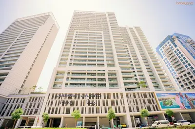 a large white building with two tall buildings at Bnbeyond's Serene Poolside Bliss in Dubai