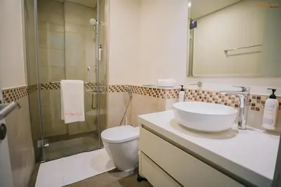 a bathroom with a sink and a shower and a toilet at Bnbeyond's Serene Poolside Bliss in Dubai