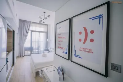 a white room with two framed pictures on a wall at Bnbeyond's Modern Marina Pad in Dubai