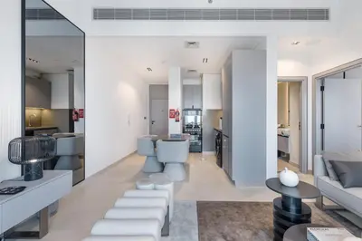 a living room with white furniture and a kitchen at ALiving Modern & Chic 1BR I MAG960 in Dubai