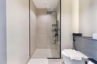 a bathroom with a shower and a white toilet at ALiving Modern & Chic 1BR I MAG960 in Dubai
