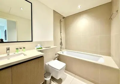a bathroom with a tub and a toilet and a sink at Luxurious and Spacious 2BR Burj Crown Downtown in Dubai