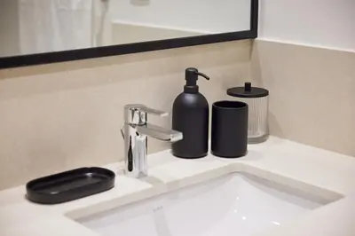 a bathroom sink with a black soap dispenser on it at Spacious 1BR Burj Crown Downtown in Dubai