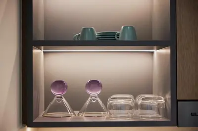 three wine glasses and plates on a shelf at Spacious 1BR Burj Crown Downtown in Dubai