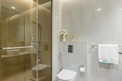 a white bathroom with a toilet and a shower at Designer Studio w Burj Khalifa view in Peninsula in Dubai